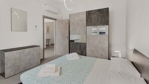 Un dormitorio moderno con cama, cómoda, espejo y vestidor.