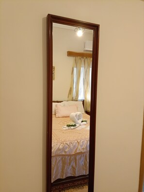 A bedroom with a bed, pillows, and a towel arrangement. - Maria's Cozy Getaway in Glyfada (Glyfada)