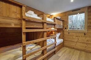 A wooden bunk bed room with a window providing a view of trees. - Chalet Phoenix - 14 guests - Spa & Hammam, Gérardmer (Gérardmer)