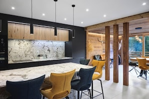 A modern kitchen with a marble countertop and pendant lighting. - Chalet Phoenix - 14 guests - Spa & Hammam, Gérardmer (Gérardmer)