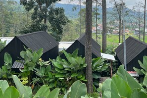 A row of black-roofed buildings surrounded by lush greenery. - TwoSpaces Living at Welirang Resort Syariah (Pacet)