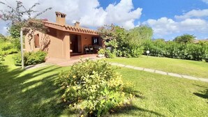 A single-story house with a brown exterior, a small porch, and a well-maintained garden. - <b></b>Located on the southeastern coast of Sardinia, 20 km from Villasimius, <b>Villa Venere</b> is situated approximately 2 km from the center of Costa Rei. Surrounded by a spacious and well-kept private garden of about 200 sqm, this charming villa is  (Costa Rei)