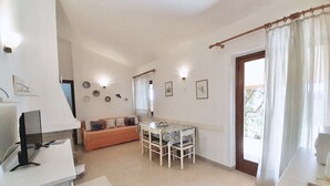A compact living space with a kitchenette, a dining area, and a sofa. - <b></b>Located on the southeastern coast of Sardinia, 20 km from Villasimius, <b>Villa Venere</b> is situated approximately 2 km from the center of Costa Rei. Surrounded by a spacious and well-kept private garden of about 200 sqm, this charming villa is  (Costa Rei)