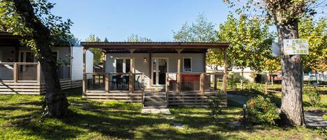 A small, single-story building with a covered porch and a fenced patio area.