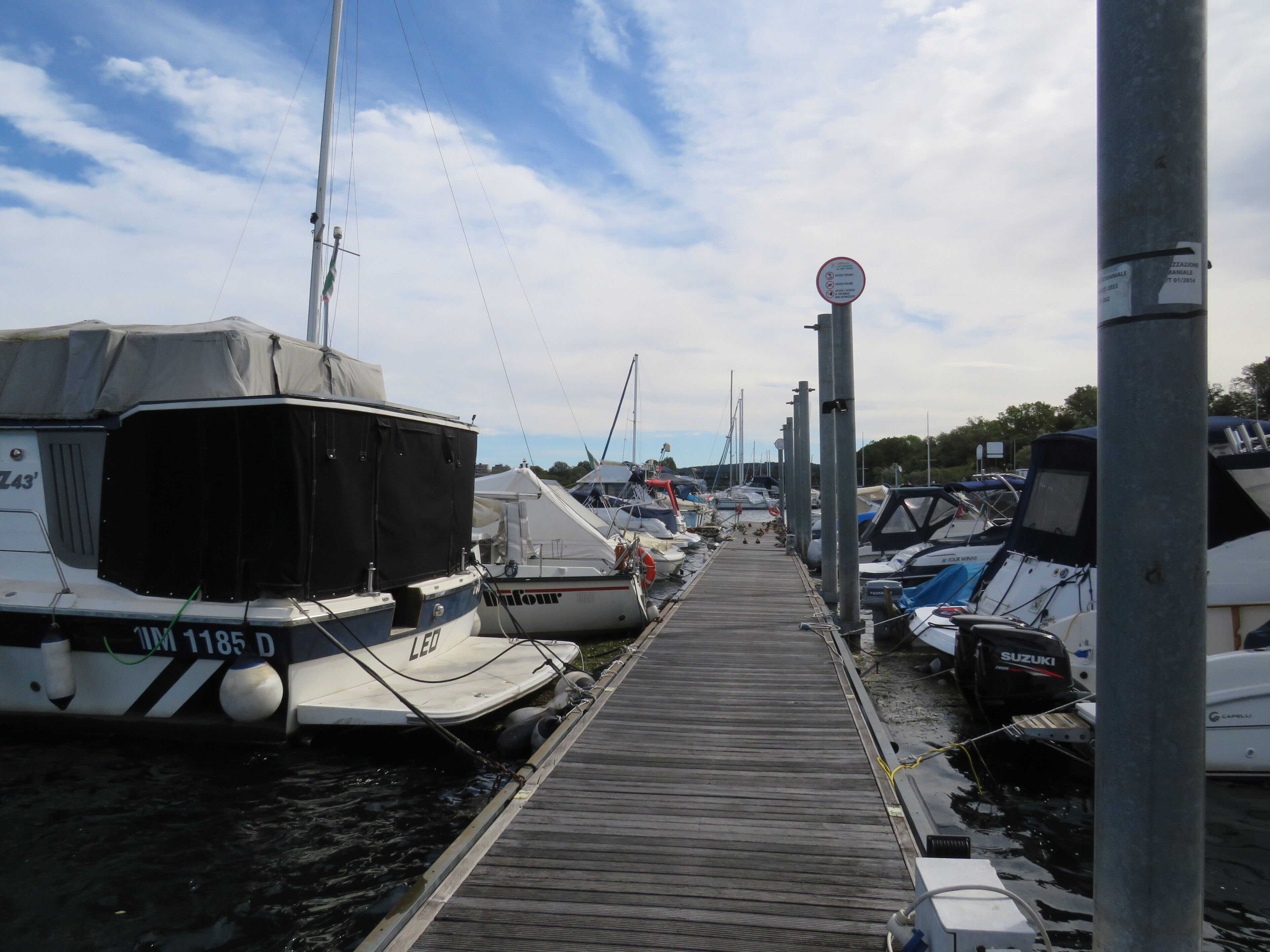 A marina with boats docked along a wooden pier.