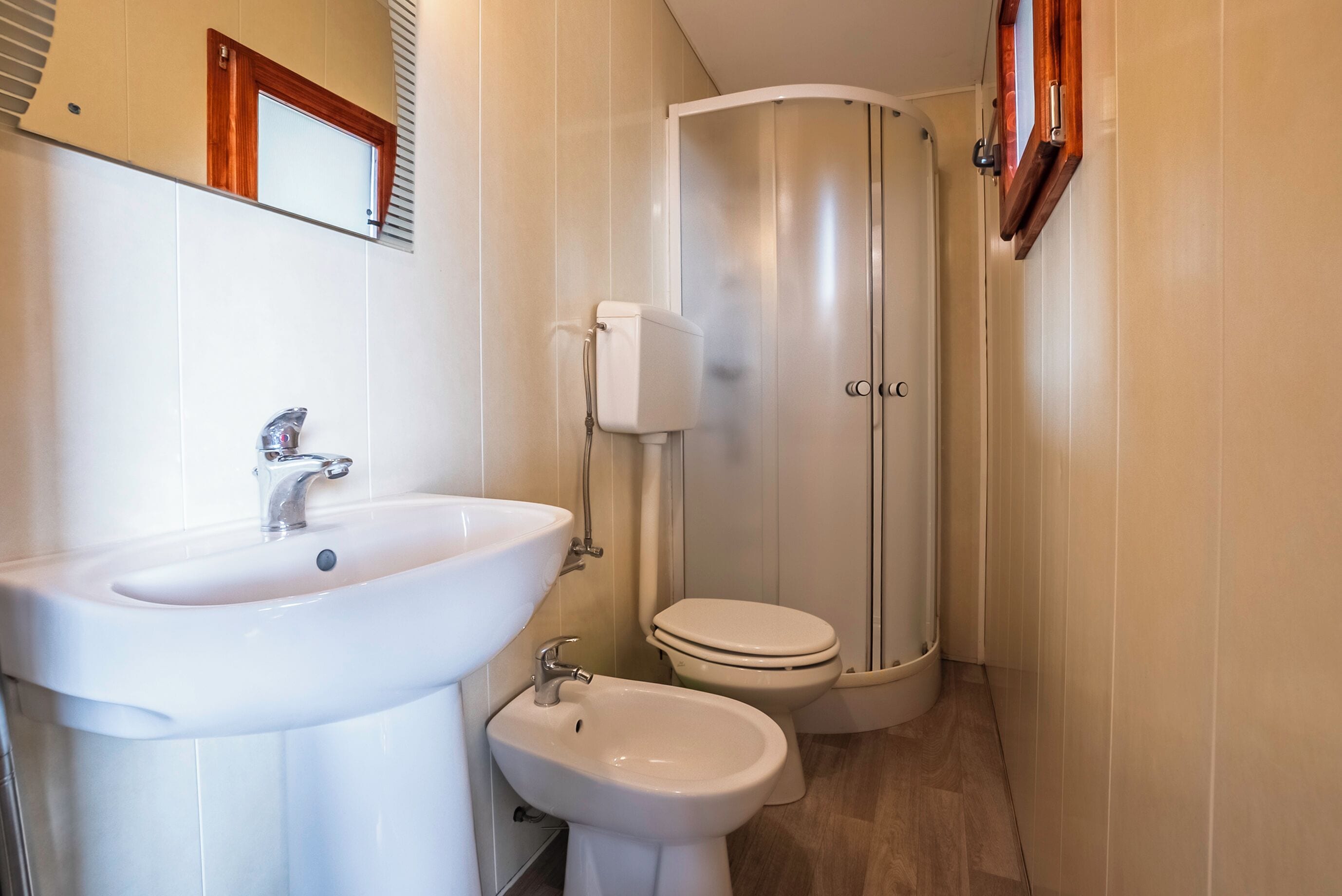 Une salle de bain avec un lavabo blanc, un bidet et des toilettes.