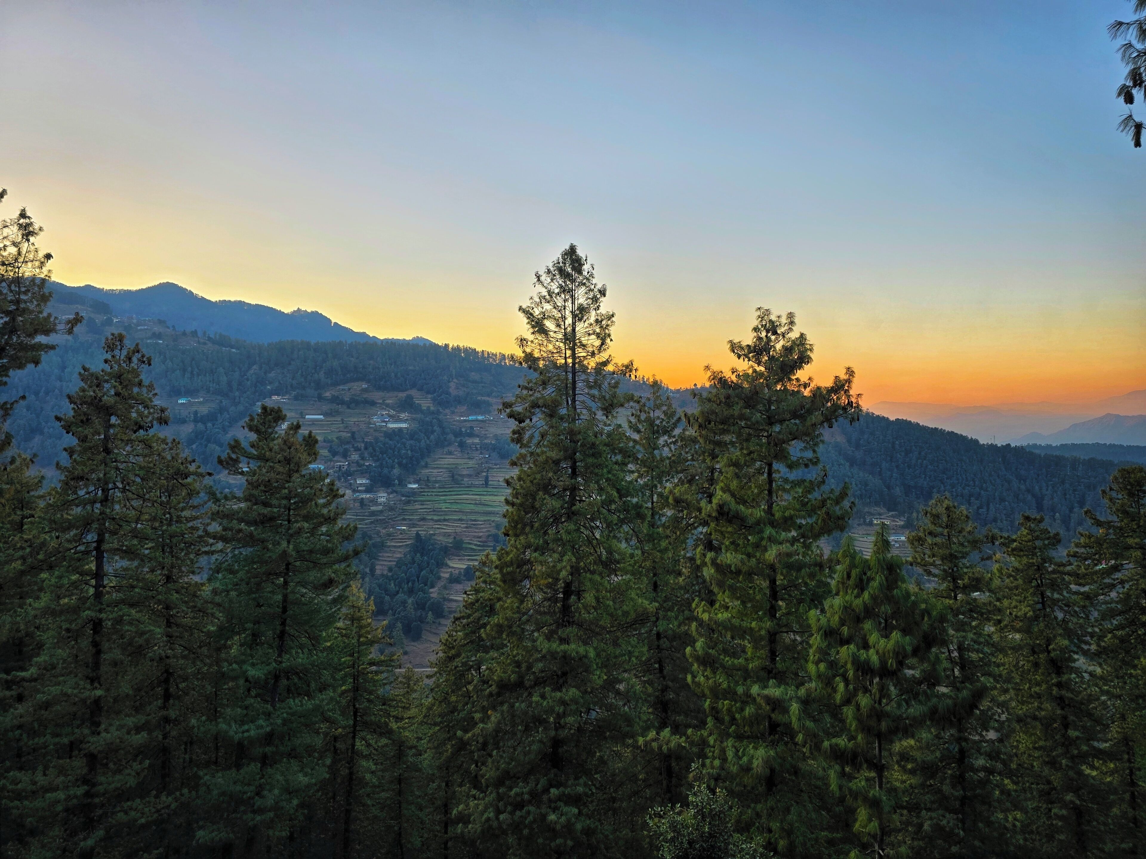 A mountainous landscape with dense forests and a valley.