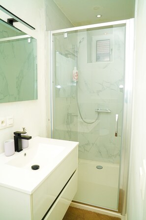 Apartamento básico | Baño | Ducha, artículos de higiene personal gratuitos y secador de pelo