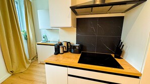 Eenvoudig appartement | Privékeuken | Een koelkast, een oven, een kookplaat, kookgerei, borden en bestek