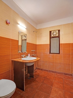 Une salle de bain avec un lavabo, un miroir et des toilettes.