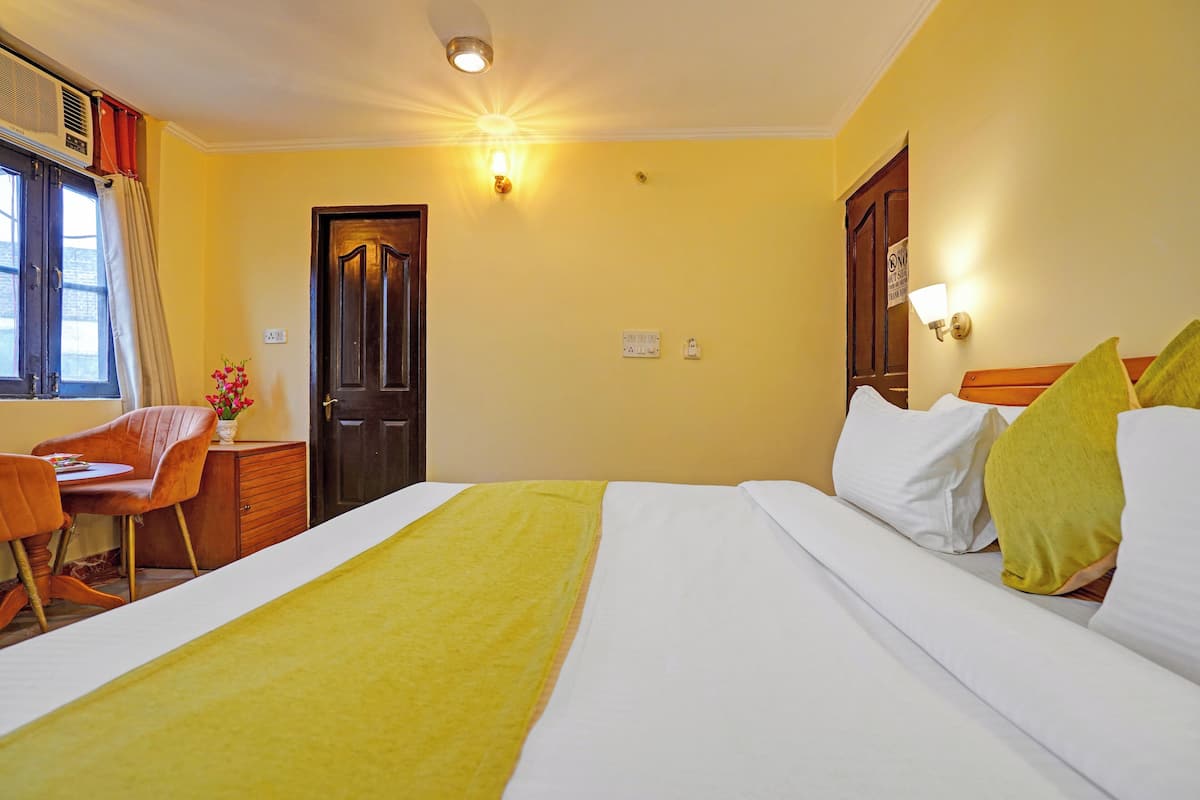Une chambre d  ’hôtel avec un lit, un bureau et une chaise.