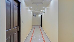 Un couloir doté d’un sol en marbre et d’une porte située sur le côté gauche.