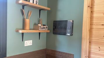 Køleskab, kogeplade, køkkentøj/tallerkener/redskaber, spisebord