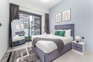 Ein modernes Schlafzimmer mit einem großen Bett, einem Nachttisch, einem Spiegel und Blick ins Freie.