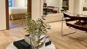 Ein modernes Hotelzimmer mit Bett, Essbereich und Wohnbereich.