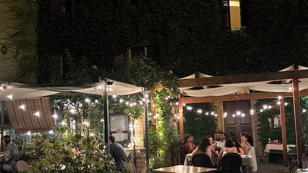 An outdoor dining area with tables and chairs, surrounded by greenery and string lights. - Relais Portaluna Incanto / 2BR, Sleeps 6, Garden, Langhe Views, Wifi (Piemonte)