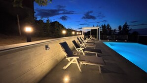 A poolside area with lounge chairs and a pool at dusk. - Relais Portaluna Incanto / 2BR, Sleeps 6, Garden, Langhe Views, Wifi (Piemonte)