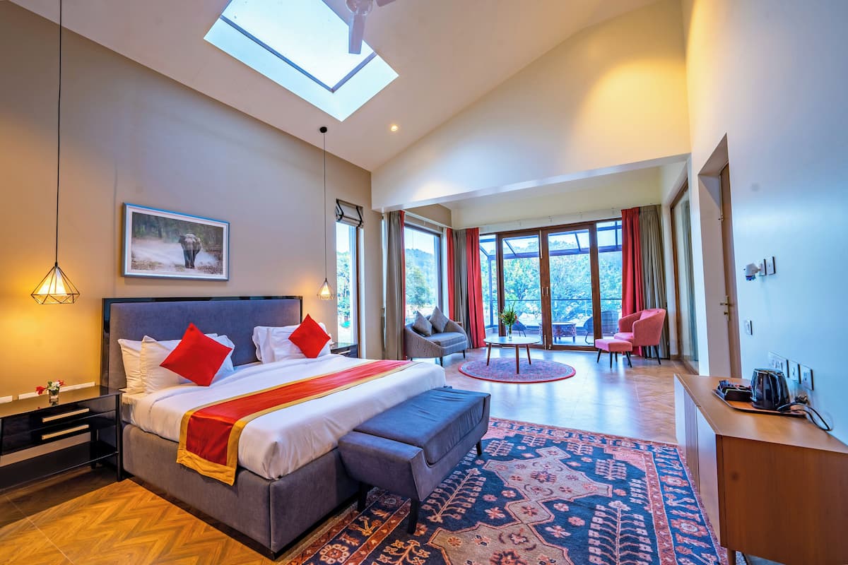 Une chambre d’hôtel moderne, dotée d’un grand lit, d’un bureau, d’une chaise et offrant une vue sur l’extérieur.