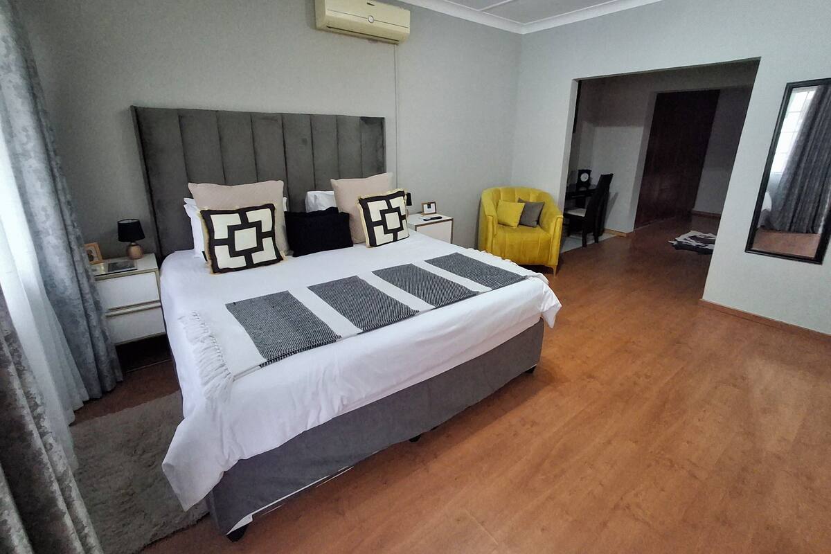 Een moderne hotelkamer met een groot bed, een nachtkastje, een stoel en een bureau met een stoel.