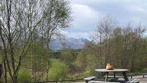 A couple in a hot tub with a view of trees and mountains. - Camden House Holidays Scottish Highlands Villa (Spean Bridge)