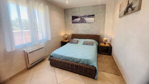 Una camera da letto con un letto, due comodini, un quadro appeso al muro e una finestra con tende.