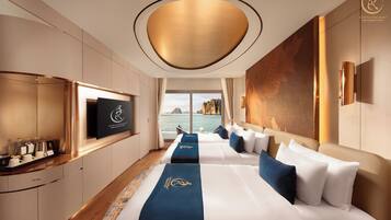 Ein modernes Hotelzimmer mit einem großen Bett, einem Fernseher und Blick auf das Meer.