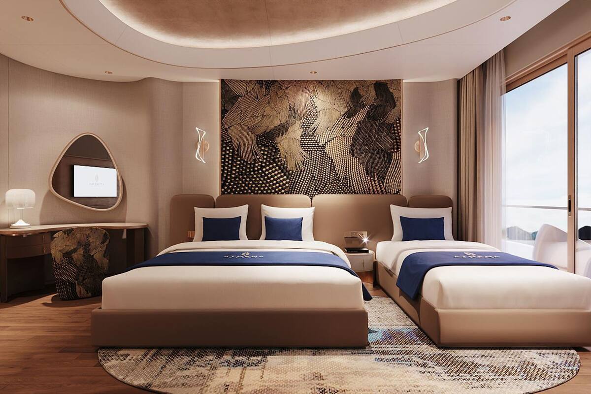A modern hotel room with a large bed, a desk, and a large window.