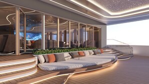A modern interior with a curved seating area, glass partitions, and a view of the sky. - Athena Premium Cruise Halong Bay (Bai Chay)