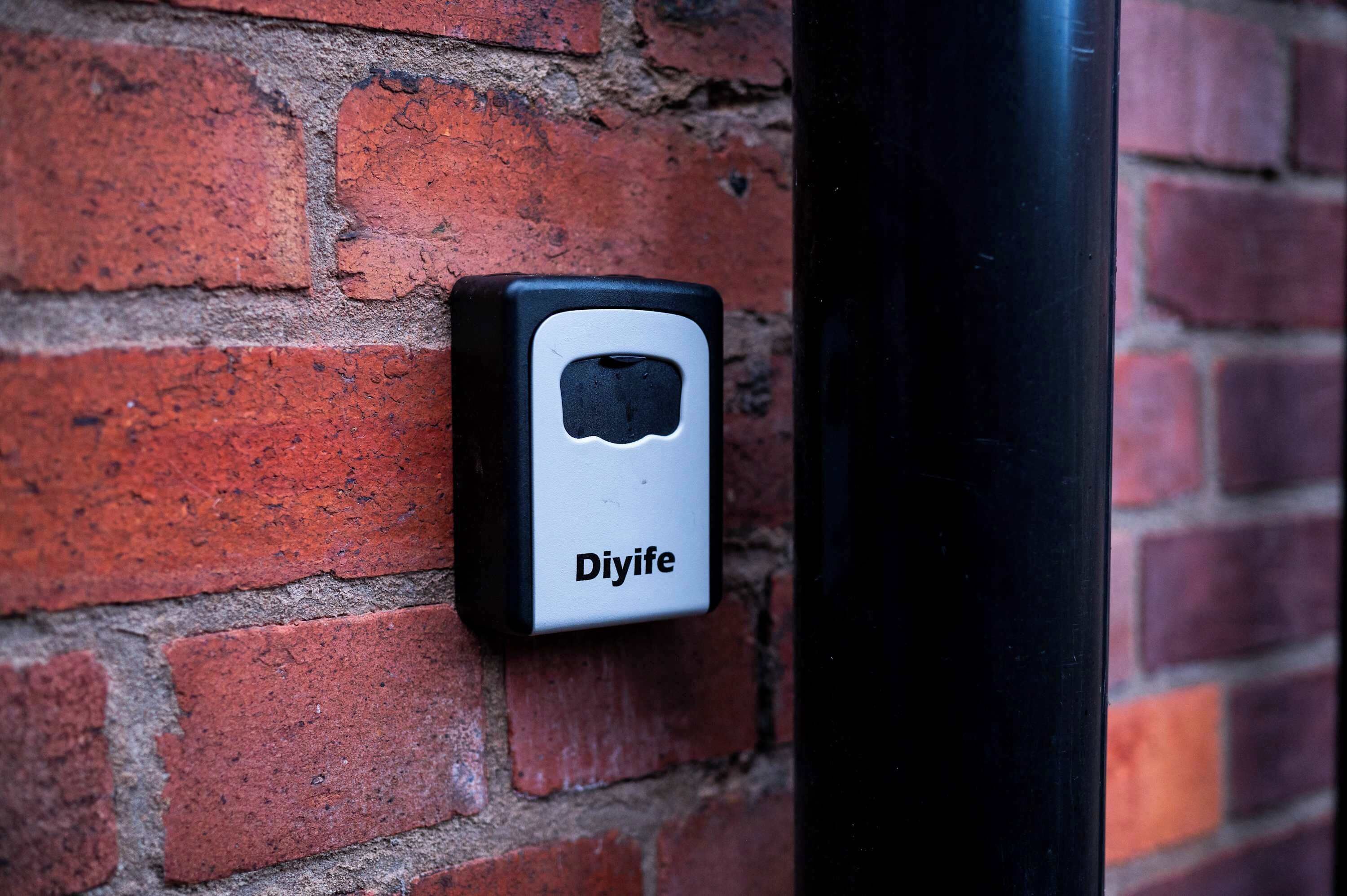 Un muro de ladrillo con un dispositivo blanco etiquetado como "Diyife" montado.