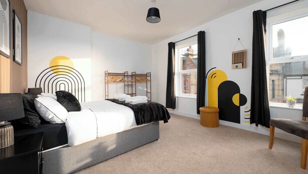 A modern bedroom with a bed, bedside table, lamp, and a window with curtains. - Monks Quarters-Luxe 3 Bed, Private Parking x2 Cars (Lincolnshire)