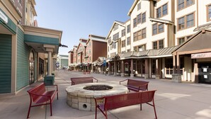 A plaza with outdoor seating and a fire pit, surrounded by multi-story buildings with shops and restaurants. - Unforgettable Mountain Adventures Await at Marriott’s Summit Watch-2 Bedroom (Park City)