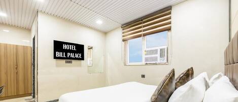 Una habitación de hotel con una cama, almohadas, una ventana con persianas y un techo con iluminación empotrada, y un letrero que dice 'HOTEL BILL PALACE'.