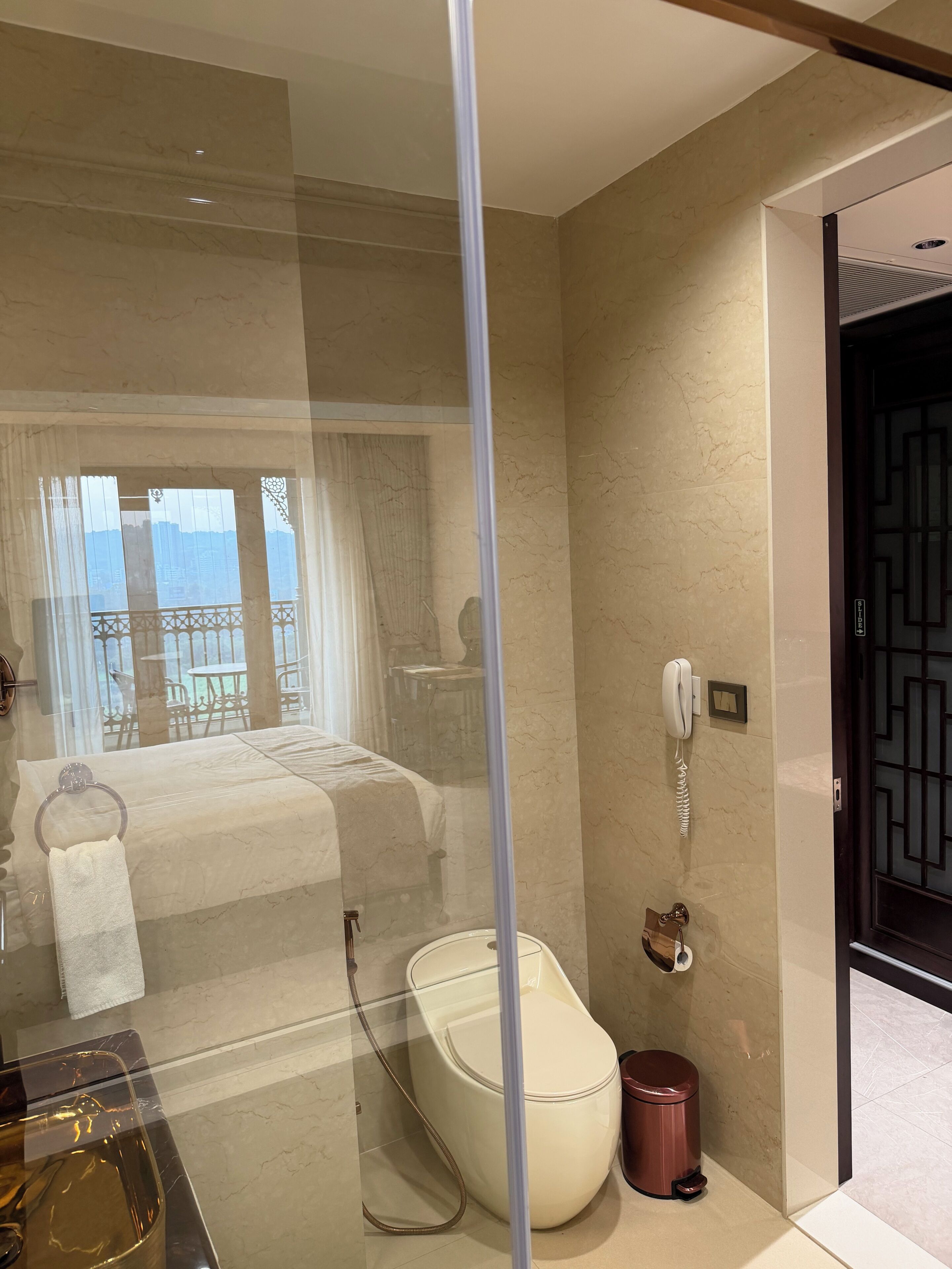 A modern bathroom with a glass-enclosed shower, a toilet, and a bidet.