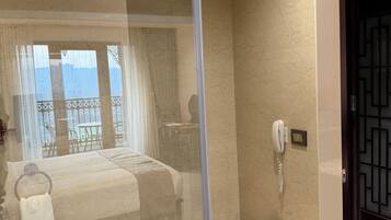 A modern bathroom with a glass-enclosed shower, a toilet, and a bidet.
