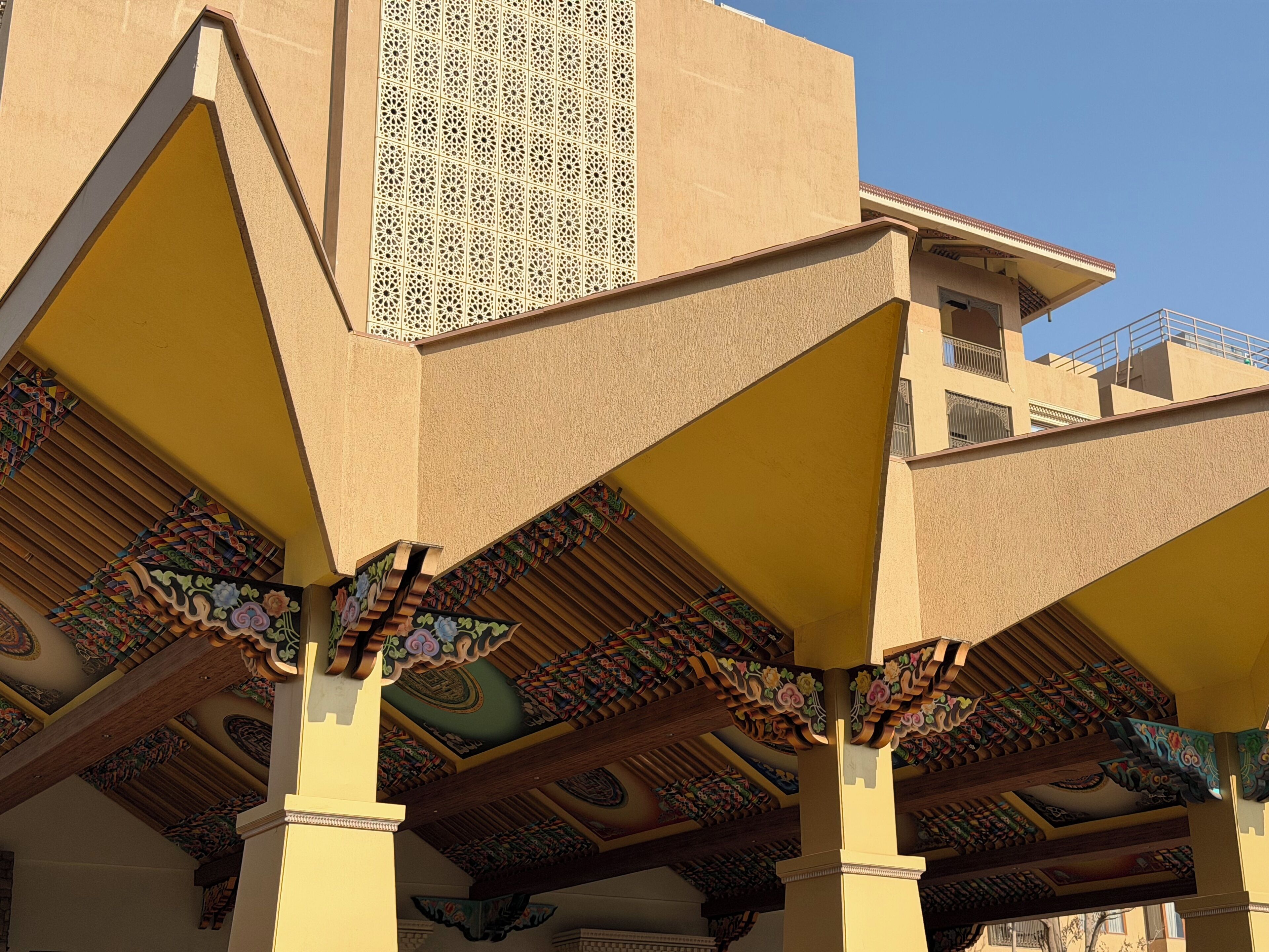 A building with a distinctive architectural style, featuring a series of triangular roofs and ornate, patterned columns.