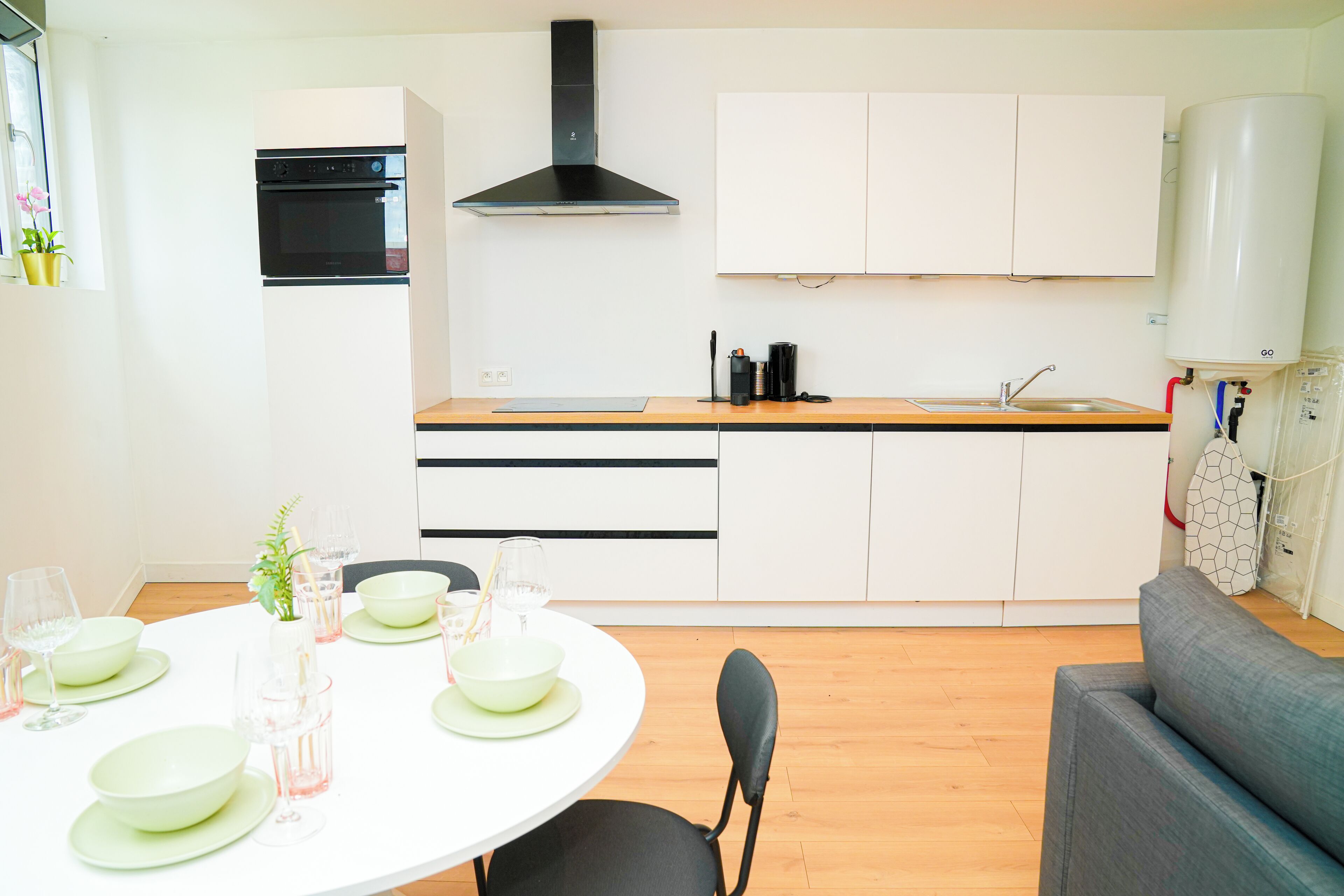 A modern kitchen with white cabinets, a black oven, and a built-in stove.