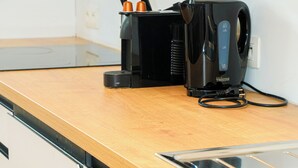 A kitchen with a black coffee maker, a knife block, and a stainless steel sink. - Cozy 1BR With Living Room Near City (Ghent)