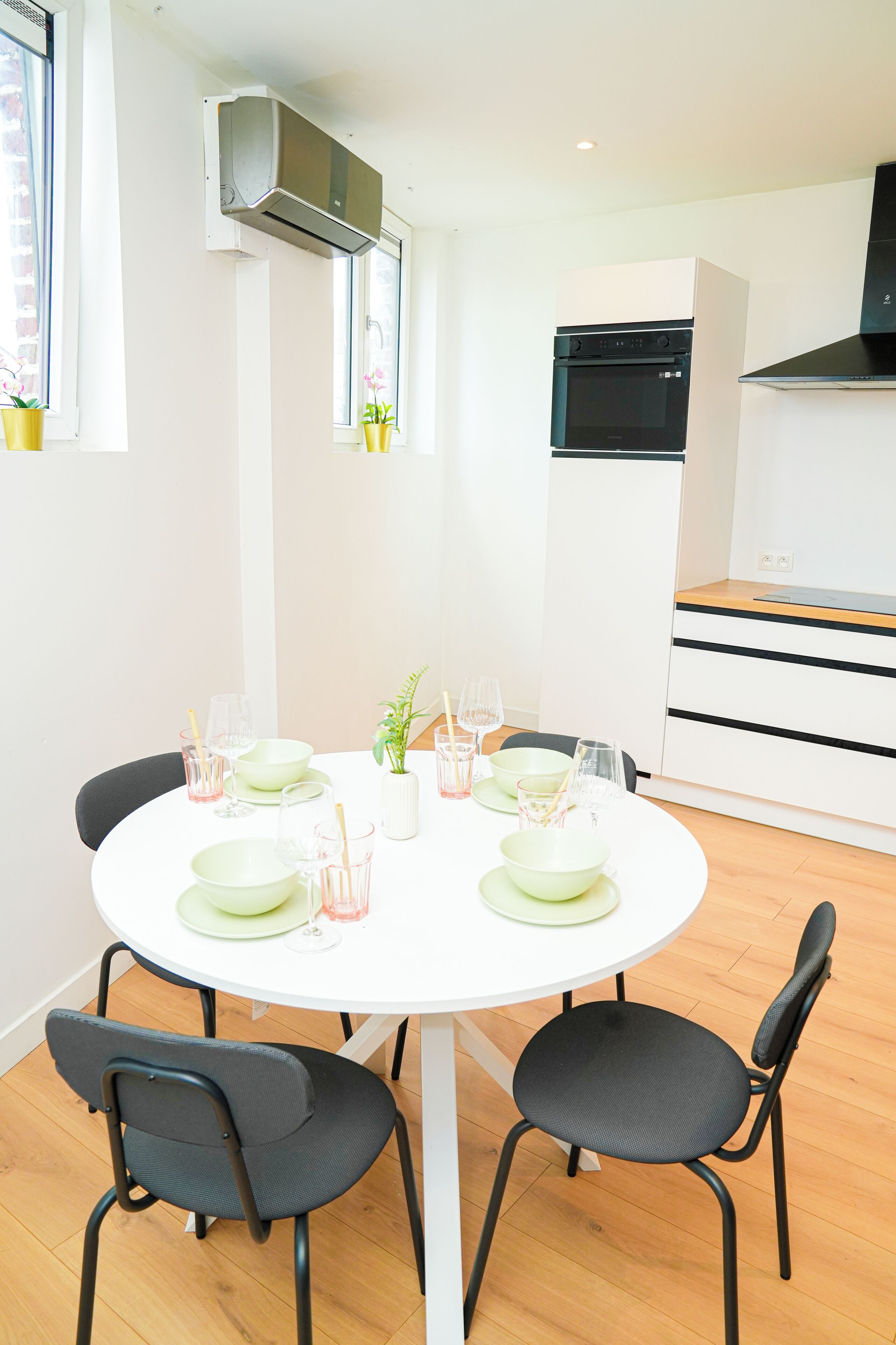 A modern kitchen with white cabinets, a black oven, and a built-in range hood.