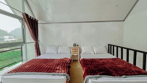 A room with two beds, a small bedside table, and a window with curtains. - Lotus Nexura Escape (Kejajar)