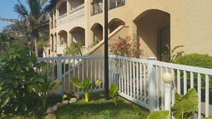 A building with multiple balconies and arches, surrounded by a white fence and greenery. - Crayfish Inn no'1 (Ramsgate)