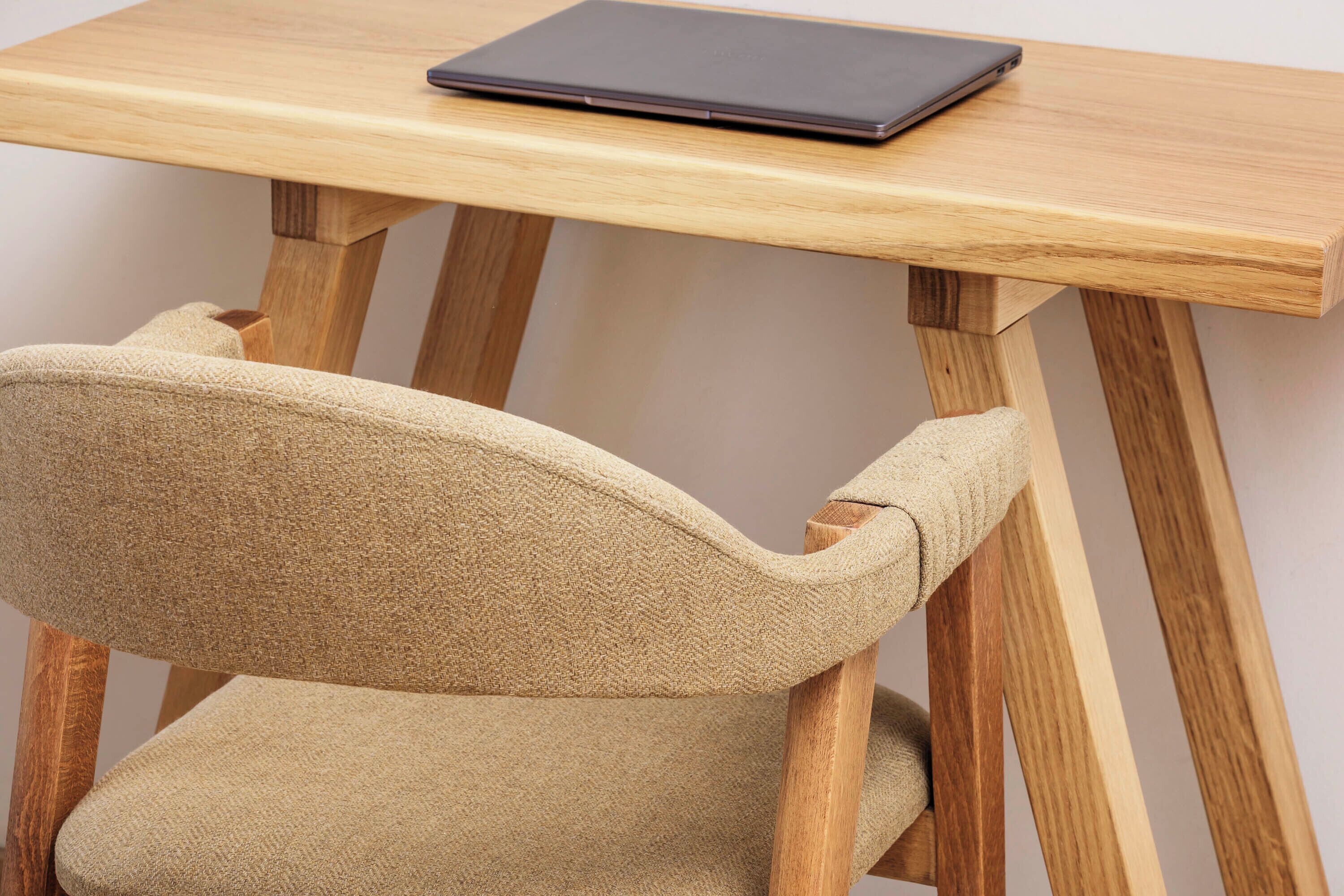 A wooden table with a laptop on top.
