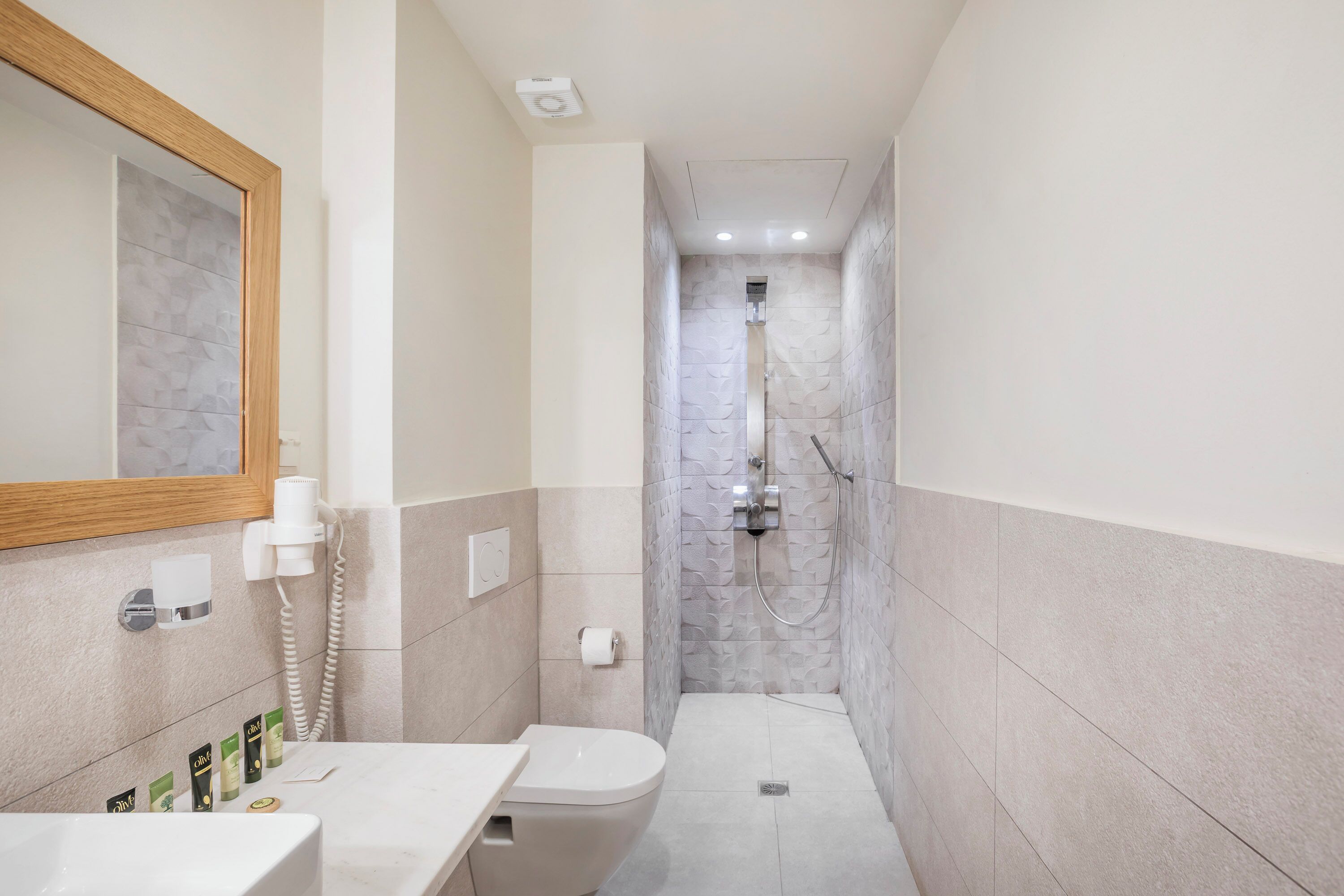 A modern bathroom with a toilet, sink, and shower.
