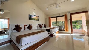 A spacious hotel room with two beds, a ceiling fan, and a large window offering a view of the outdoors. - Green Paradise Trimbak (Trimbak)