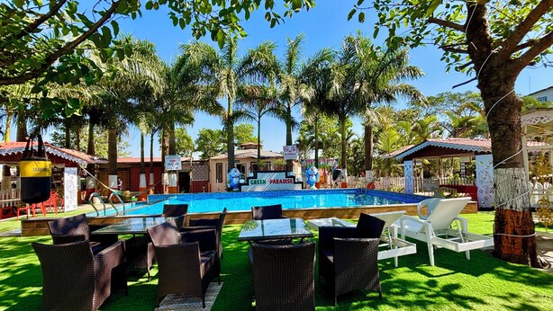 A pool area with lounge chairs and a sign for 'Green Paradise'. - Green Paradise Trimbak (Trimbak)