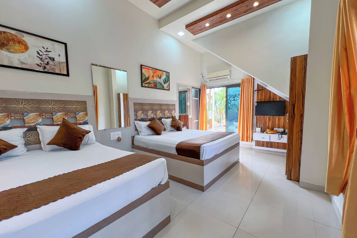 A hotel room with two beds, a large window, a TV, and a wooden ceiling.
