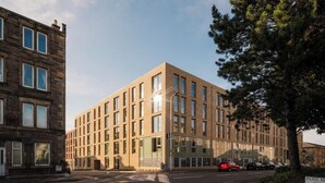 Ein modernes Gebäude mit einer symmetrischen Fassade, großen Fenstern und einem Baum im Vordergrund.