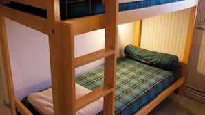 Un lit superposé avec une couverture à carreaux et un oreiller.