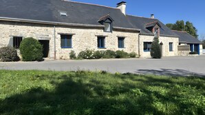 Un bâtiment en pierre doté de nombreuses fenêtres et d’une allée pavée.