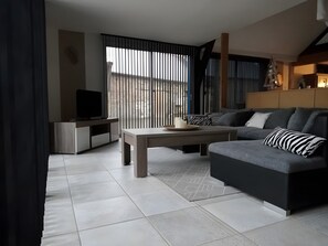 Un salon moderne avec un canapé, une table basse et un meuble pour la télévision.