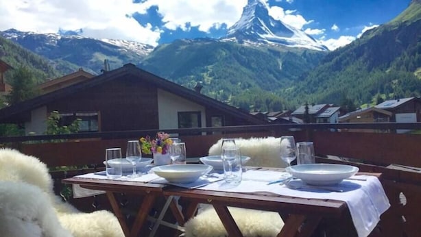 Eettafel buiten opstelling, met uitzicht op een berglandschap, inclusief een besneeuwde bergtop.